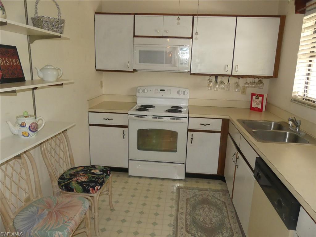 5501 Rattlesnake Hammock Road, Unit 1002 Naples, FL 34113 - Photo 3 of 9 a kitchen with a sink stove and cabinets