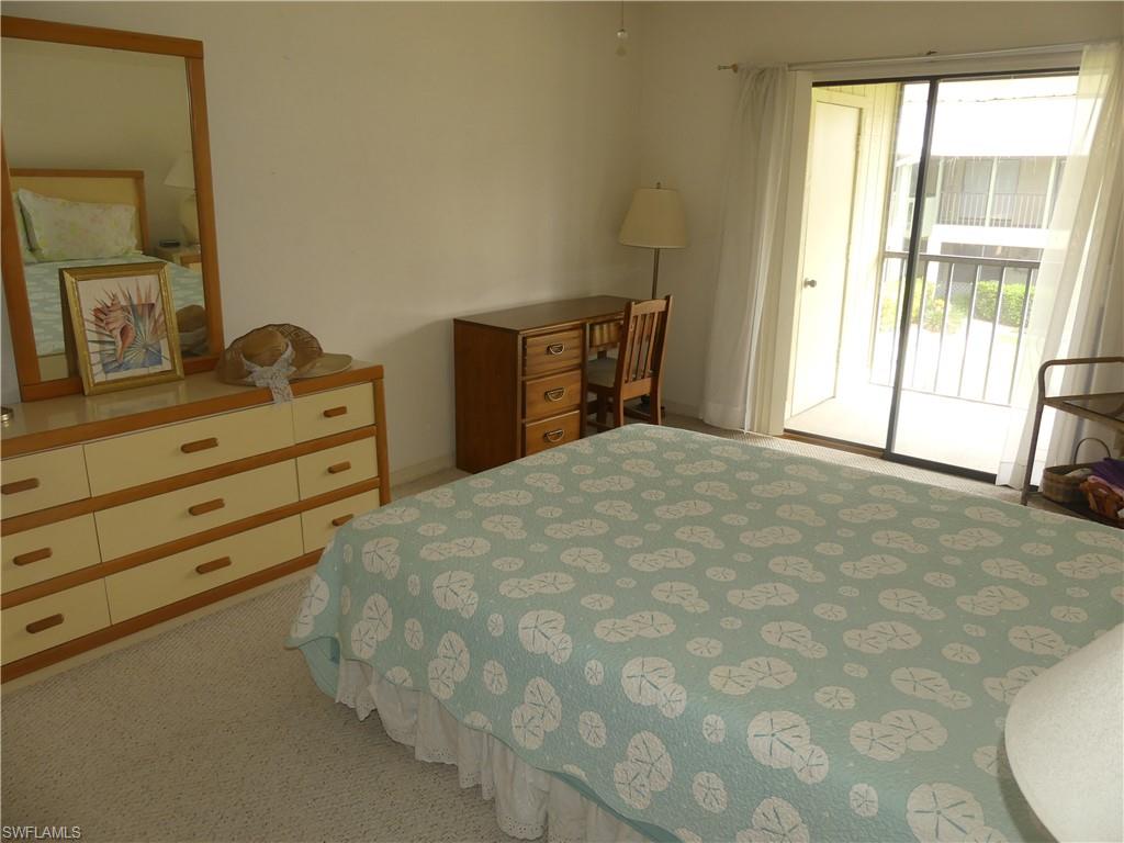 5501 Rattlesnake Hammock Road, Unit 1002 Naples, FL 34113 - Photo 4 of 9 a large bed sitting in a bedroom next to a window