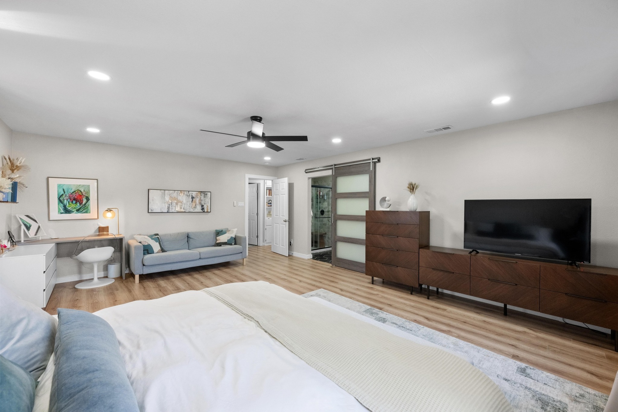 1006 Hollybluff Street Austin, TX 78753 - Photo 16 of 27 Bedroom with a barn door, light wood-style flooring, recessed lighting, and a ceiling fan