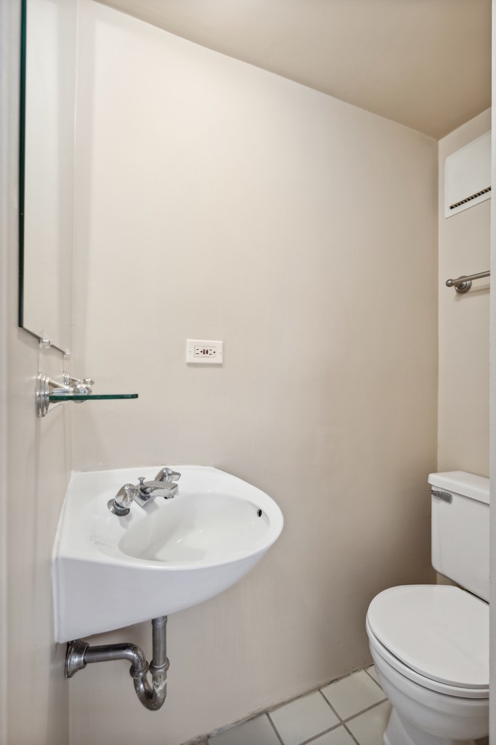 4900 North Lester Avenue, Unit 5 Chicago, IL 60630 - Photo 10 of 18 a bathroom with a sink a toilet and mirror