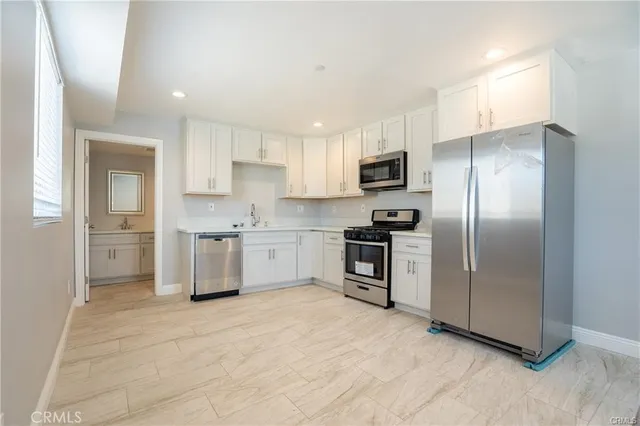a kitchen with stainless steel appliances cabinets a sink and a refrigerator