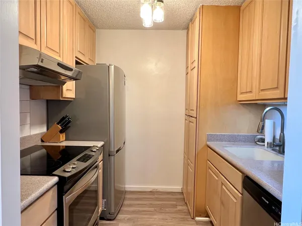 a kitchen with stainless steel appliances granite countertop a sink stove and refrigerator