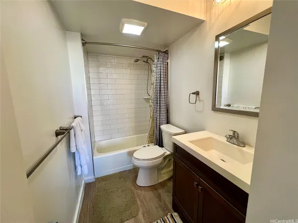 a bathroom with a sink a toilet a mirror and shower