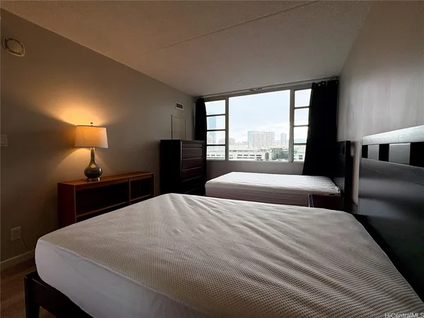 a bedroom with two beds and a large window