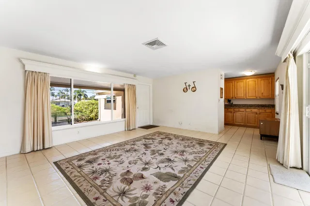 a view of a hallway to a livingroom with wooden floor and kitchen