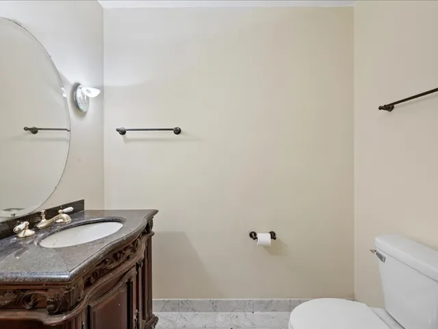 a bathroom with a granite countertop sink a toilet a mirror a bathtub and shower