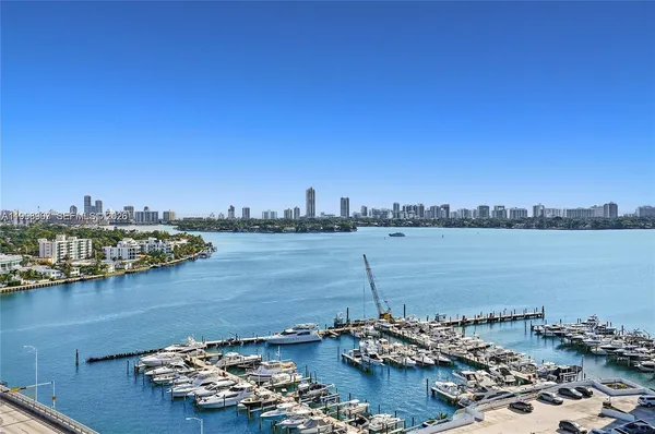 a view of a lake with boats and trees in the background