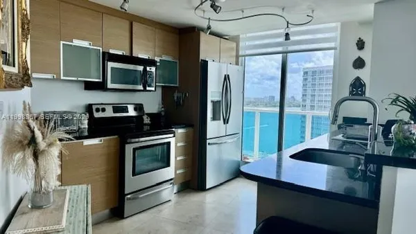 a kitchen with stainless steel appliances granite countertop a sink a stove and a refrigerator