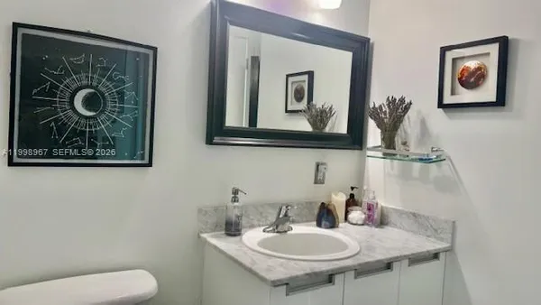 a bathroom with a toilet a sink and mirror