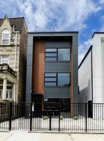 a front view of a house with a iron gate