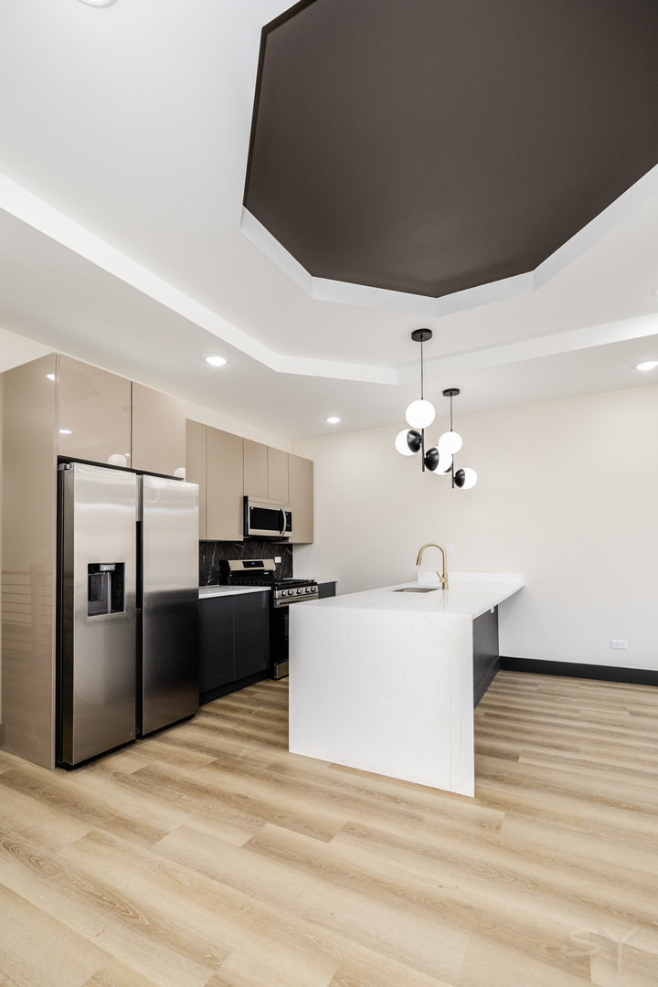 5637 South Prairie Avenue, Unit 2 Chicago, IL 60637 - Photo 4 of 15 a large white kitchen with a refrigerator a stove top oven a sink and dishwasher