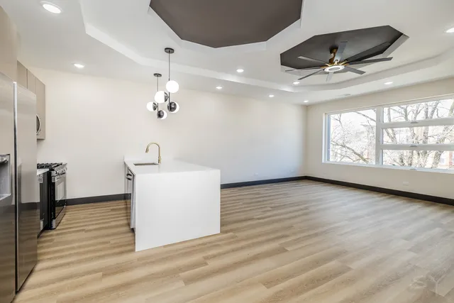 a view of a livingroom with a ceiling fan and wooden floor