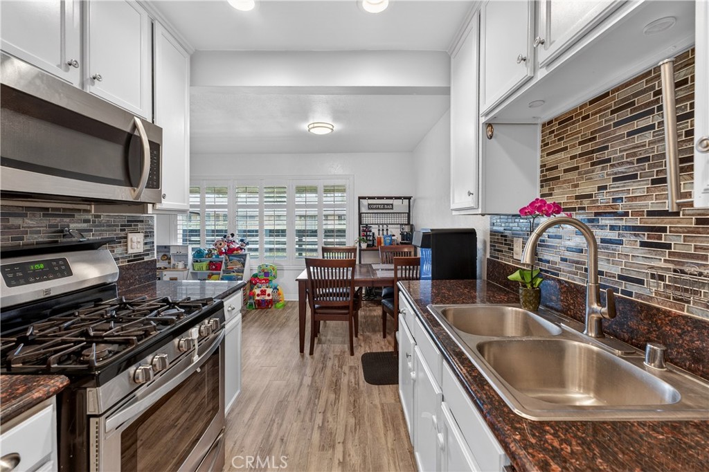 1430 West Lambert Road, Unit 384 La Habra, CA 90631 - Photo 1 of 41 a kitchen with stainless steel appliances kitchen island granite countertop a stove and a sink