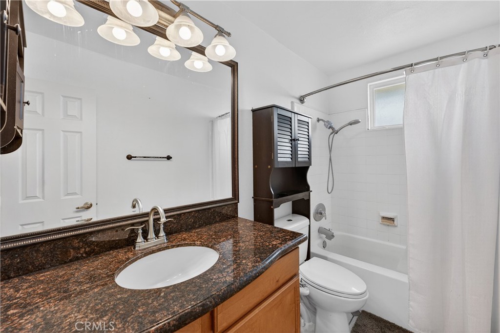1430 West Lambert Road, Unit 384 La Habra, CA 90631 - Photo 18 of 41 a bathroom with a granite countertop sink toilet mirror and a bathtub