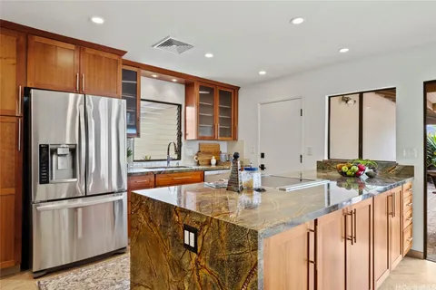 a kitchen with stainless steel appliances granite countertop a refrigerator a sink and a stove