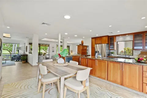 a kitchen with a dining table chairs stove refrigerator and living room view