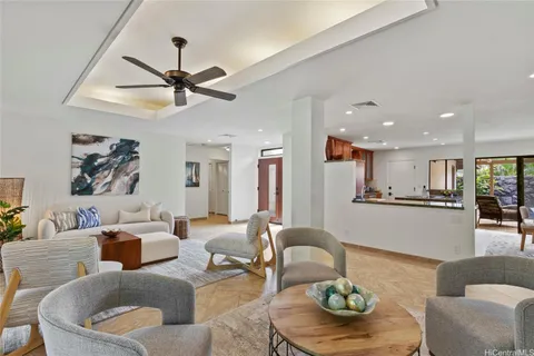 a living room with furniture and a view of kitchen