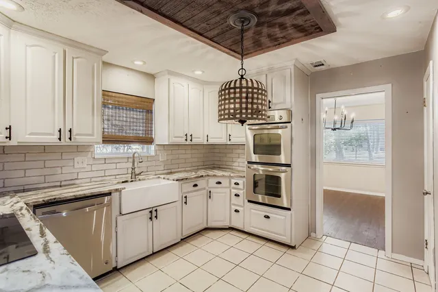 a kitchen with stainless steel appliances granite countertop a stove a sink and a microwave