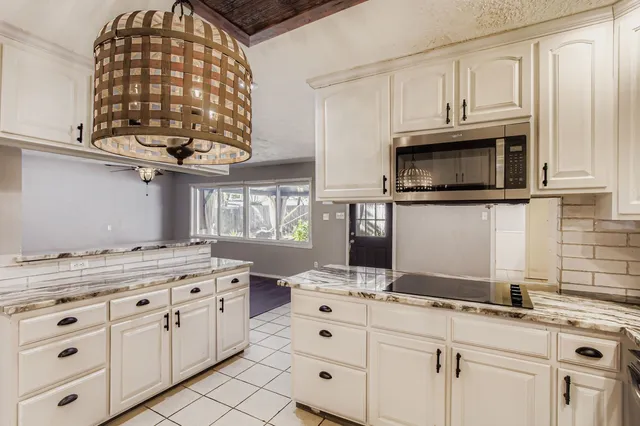 a kitchen with stainless steel appliances granite countertop a sink a stove and cabinets