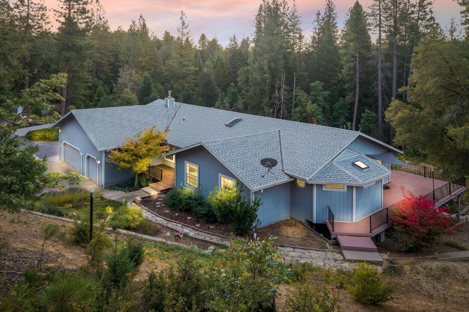 a aerial view of a house with a yard and large trees
