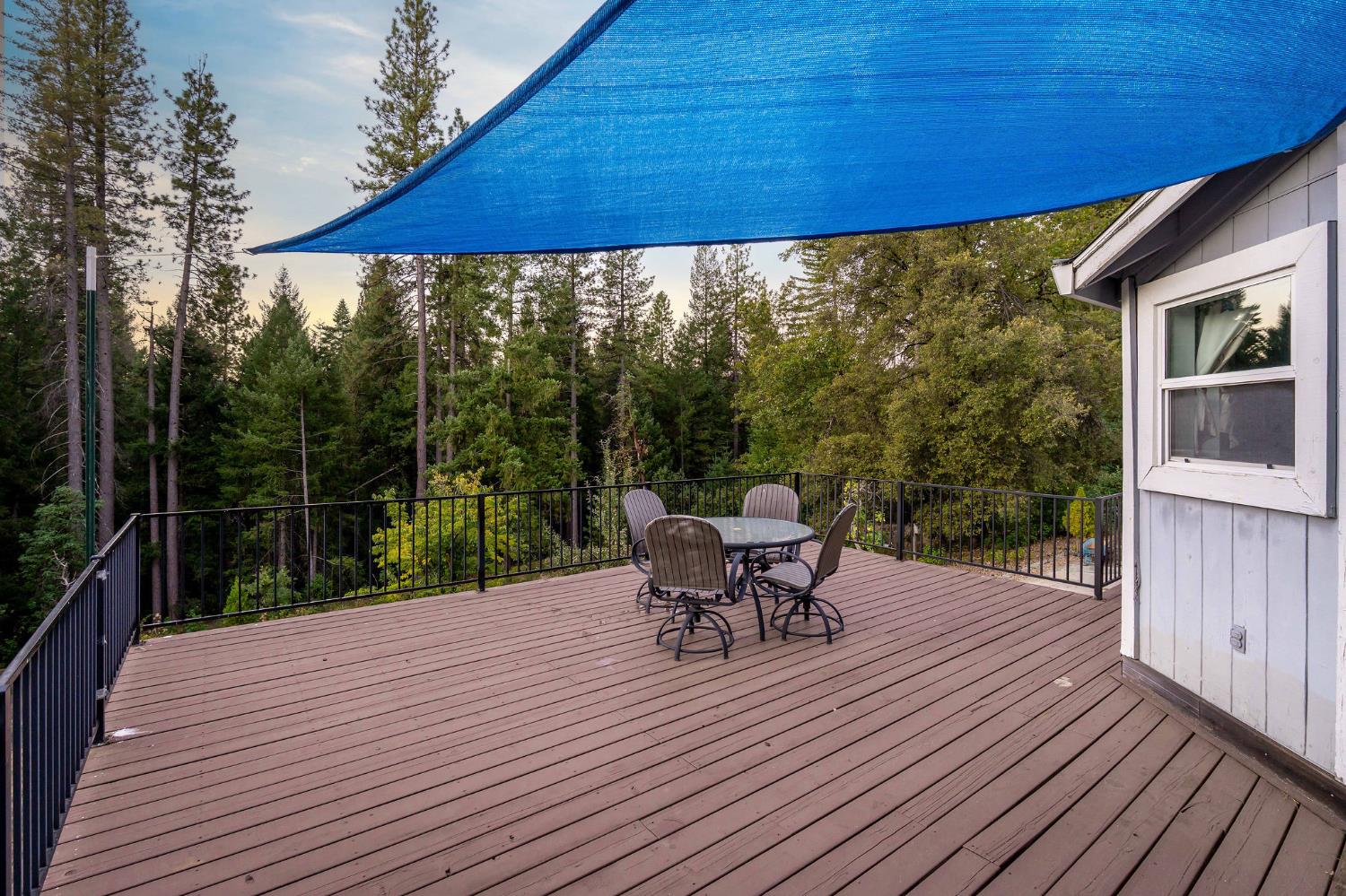 12401 Old Mine Road Grass Valley, CA 95945 - Photo 15 of 87 a view of a patio with table and chairs under an umbrella with wooden floor
