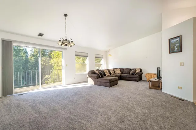 a bedroom with a bed couch and windows