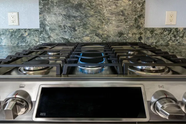 a kitchen with granite countertop cabinets stainless steel appliances a sink and a window