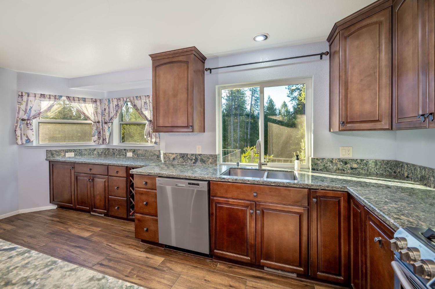 12401 Old Mine Road Grass Valley, CA 95945 - Photo 38 of 87 a kitchen with stainless steel appliances granite countertop wooden cabinets a sink and dishwasher with wooden floor