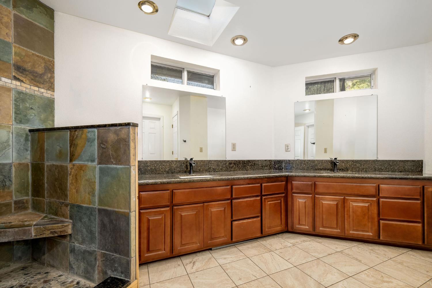 12401 Old Mine Road Grass Valley, CA 95945 - Photo 46 of 87 a spacious bathroom with a granite countertop sink a mirror and a bathtub