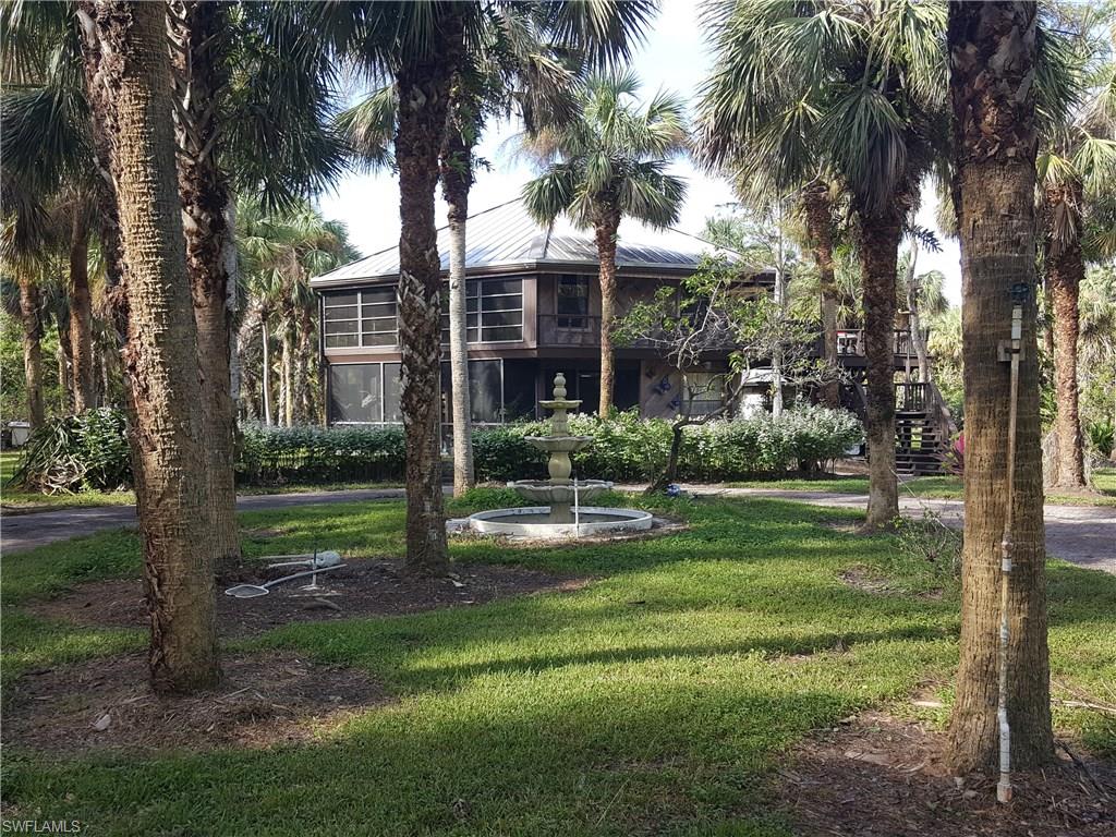 2221 Krape Road Naples, FL 34120 - Photo 2 of 24 a view of a house with a yard and palm trees