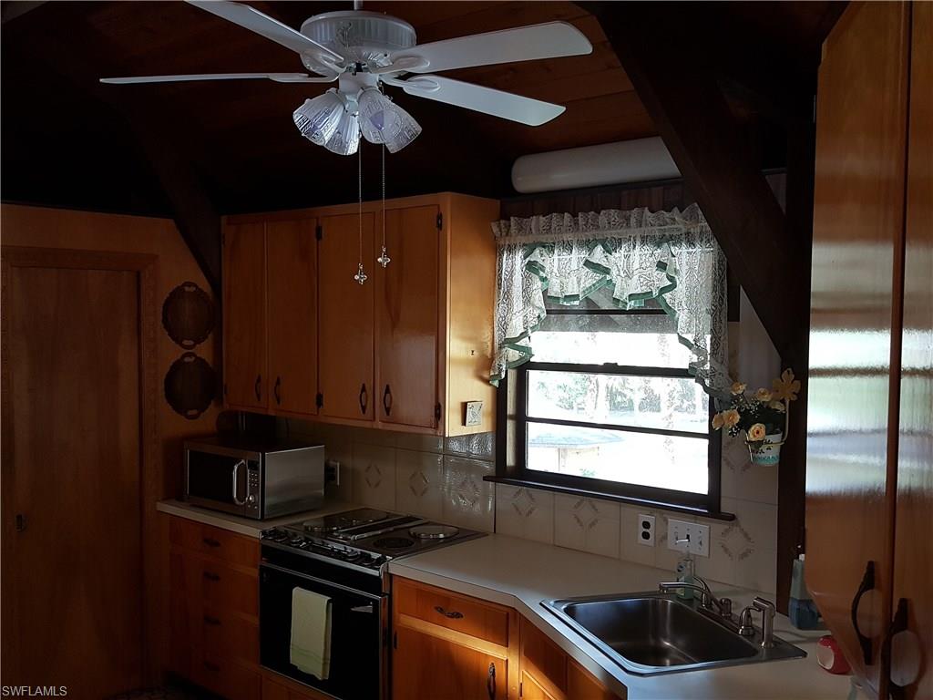 2221 Krape Road Naples, FL 34120 - Photo 8 of 24 a kitchen with a sink a stove and a microwave