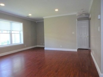 148 Newton Street, Unit 3 Boston, MA 02135 - Photo 1 of 12 an empty room with wooden floor and windows