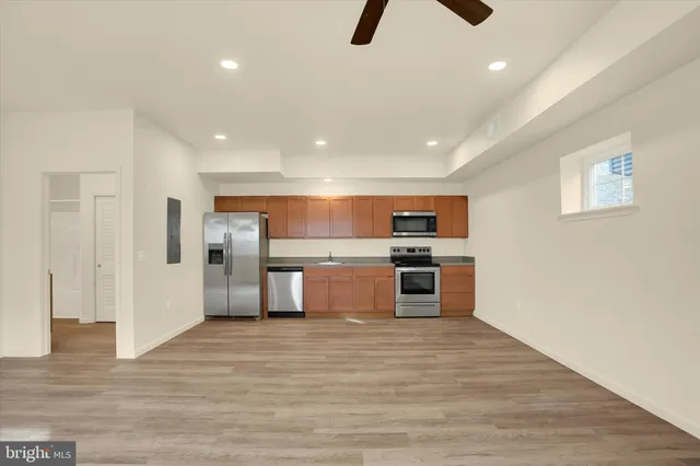 a kitchen with stainless steel appliances a stove and wooden floor