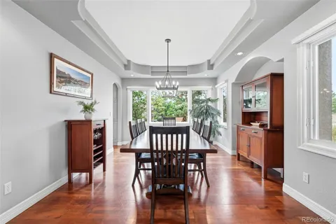 a dining room with furniture a chandelier and wooden floor