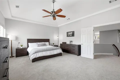 a spacious bedroom with a bed and a ceiling fan