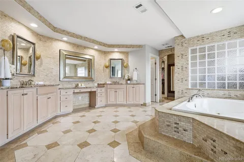 a spacious bathroom with a tub sink and mirror