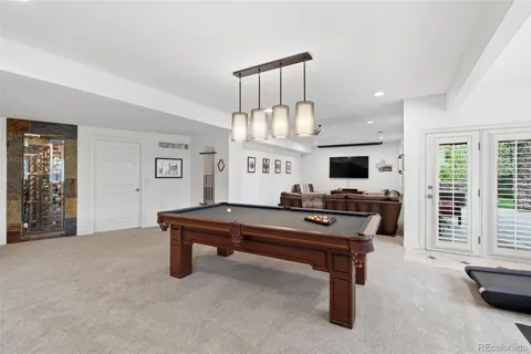 a kitchen with stainless steel appliances kitchen island a table chairs in it and wooden floors