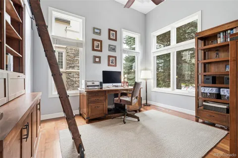 a view of a workspace with furniture and wooden floor