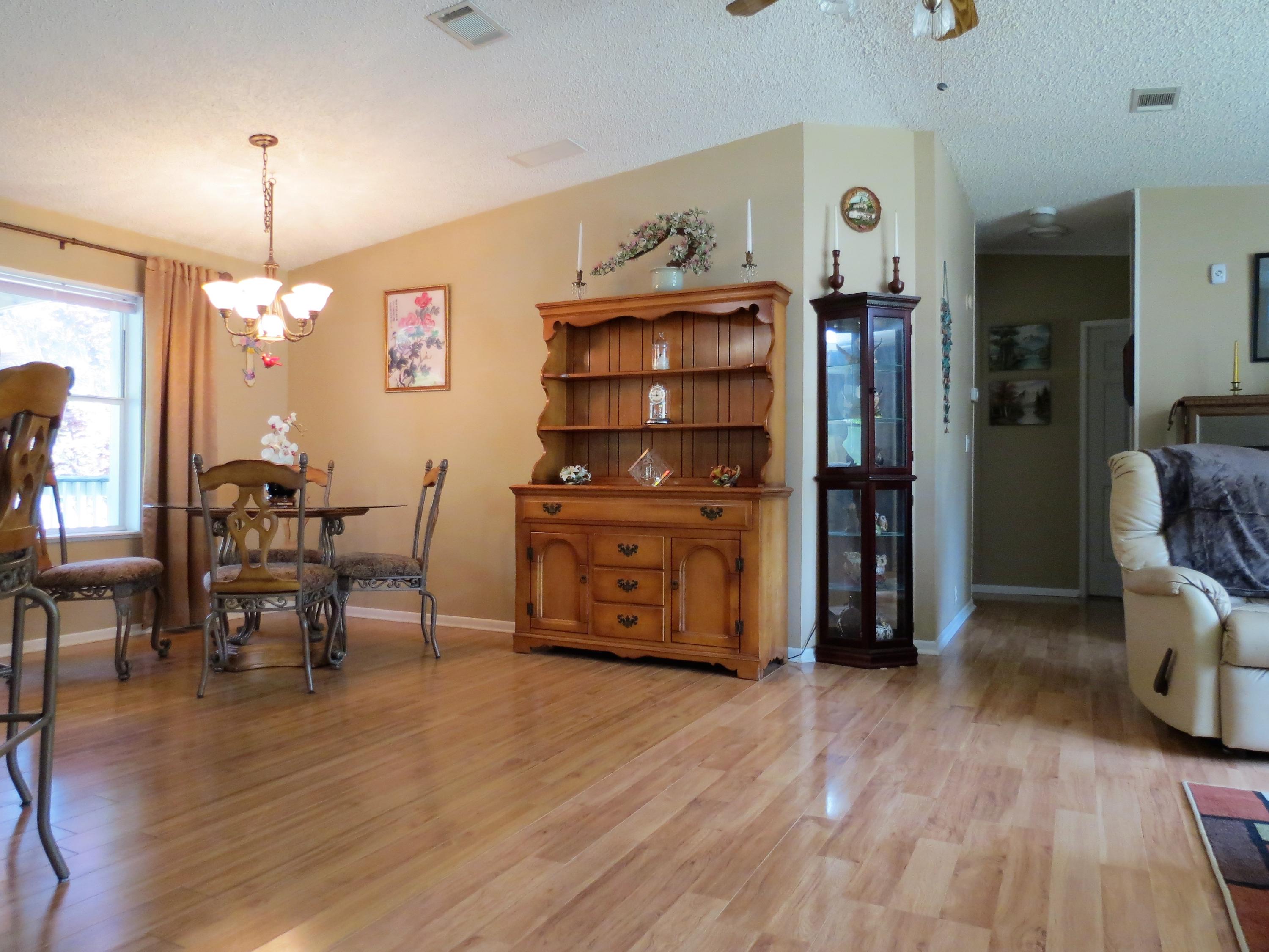 6022 Sand Hill Road Crestview, FL 32539 - Photo 8 of 32 a view of a dining room with furniture and wooden floor