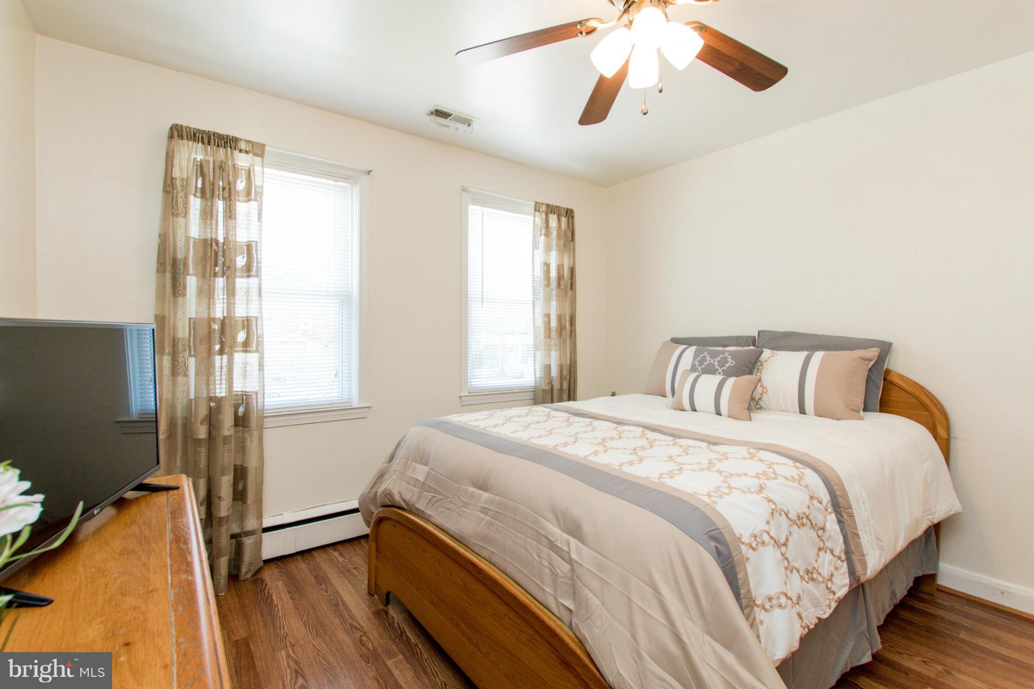5917 Glenkirk Road Baltimore, MD 21239 - Photo 14 of 30 a bedroom with a bed and wooden floor