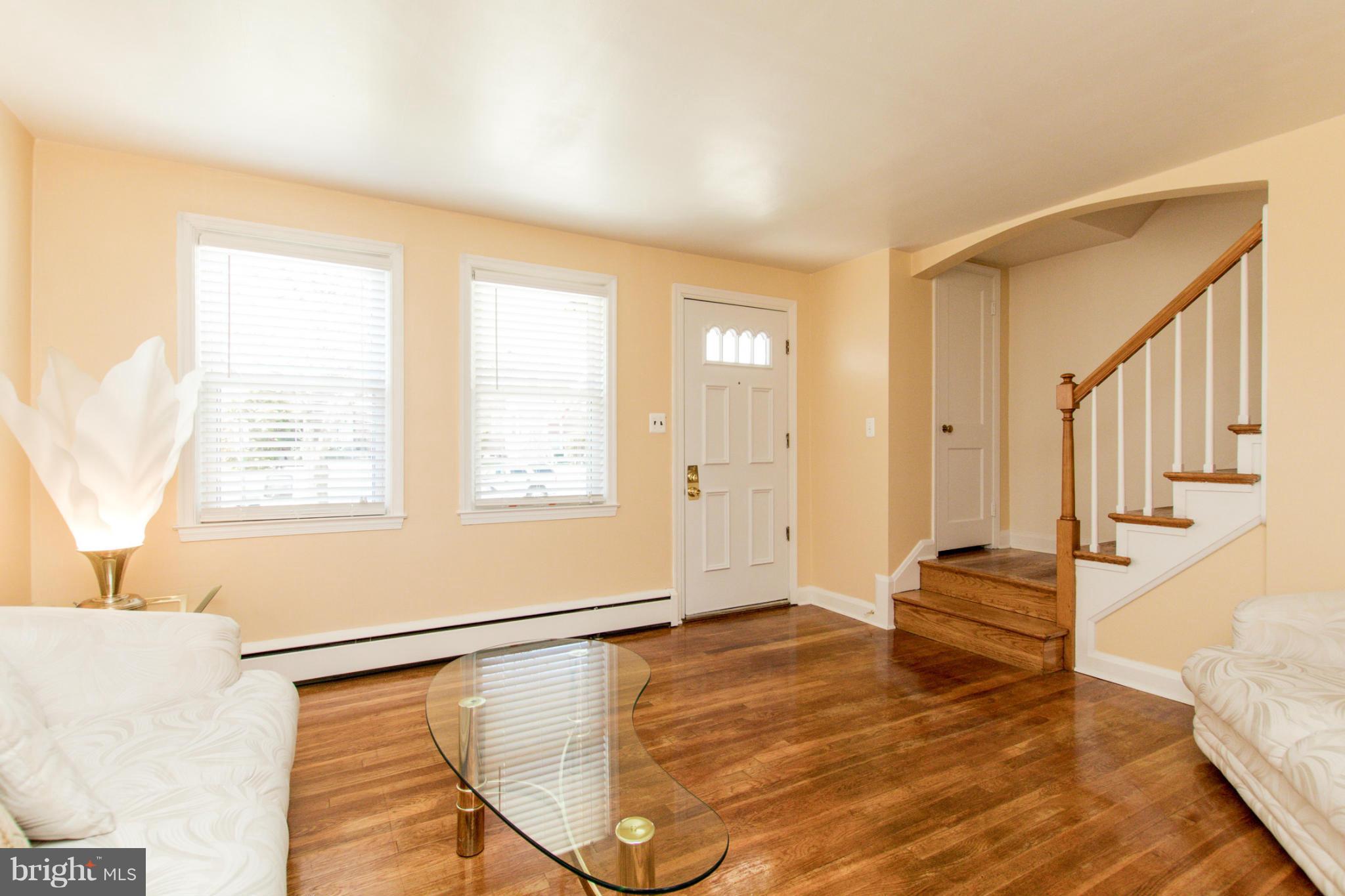 5917 Glenkirk Road Baltimore, MD 21239 - Photo 3 of 30 a view of an empty room with wooden floor and a window