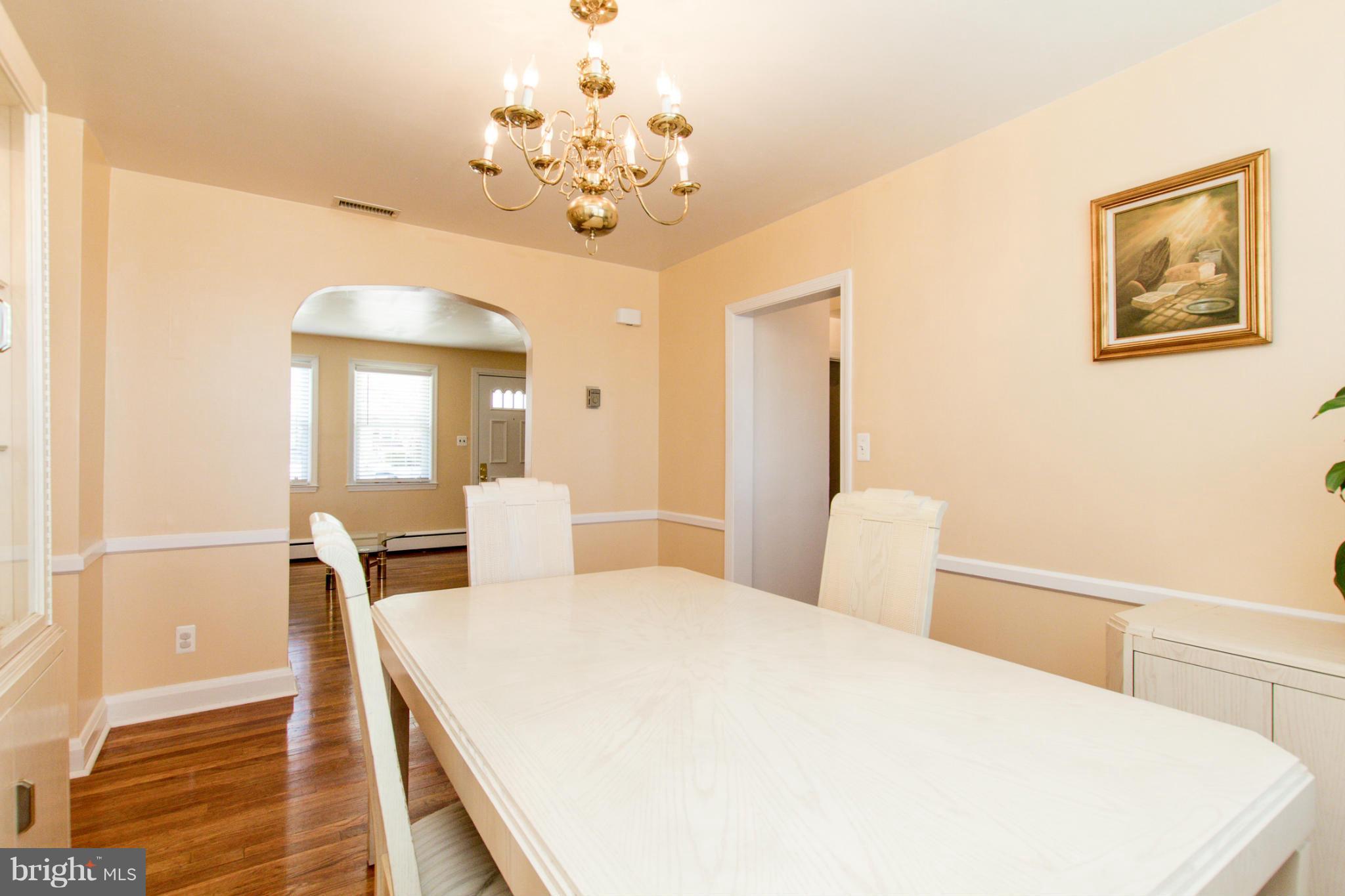 5917 Glenkirk Road Baltimore, MD 21239 - Photo 8 of 30 a spacious bedroom with a large bed and a chandelier