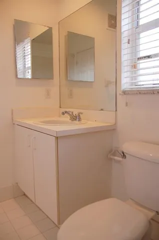 a white toilet sitting next to a bathroom sink