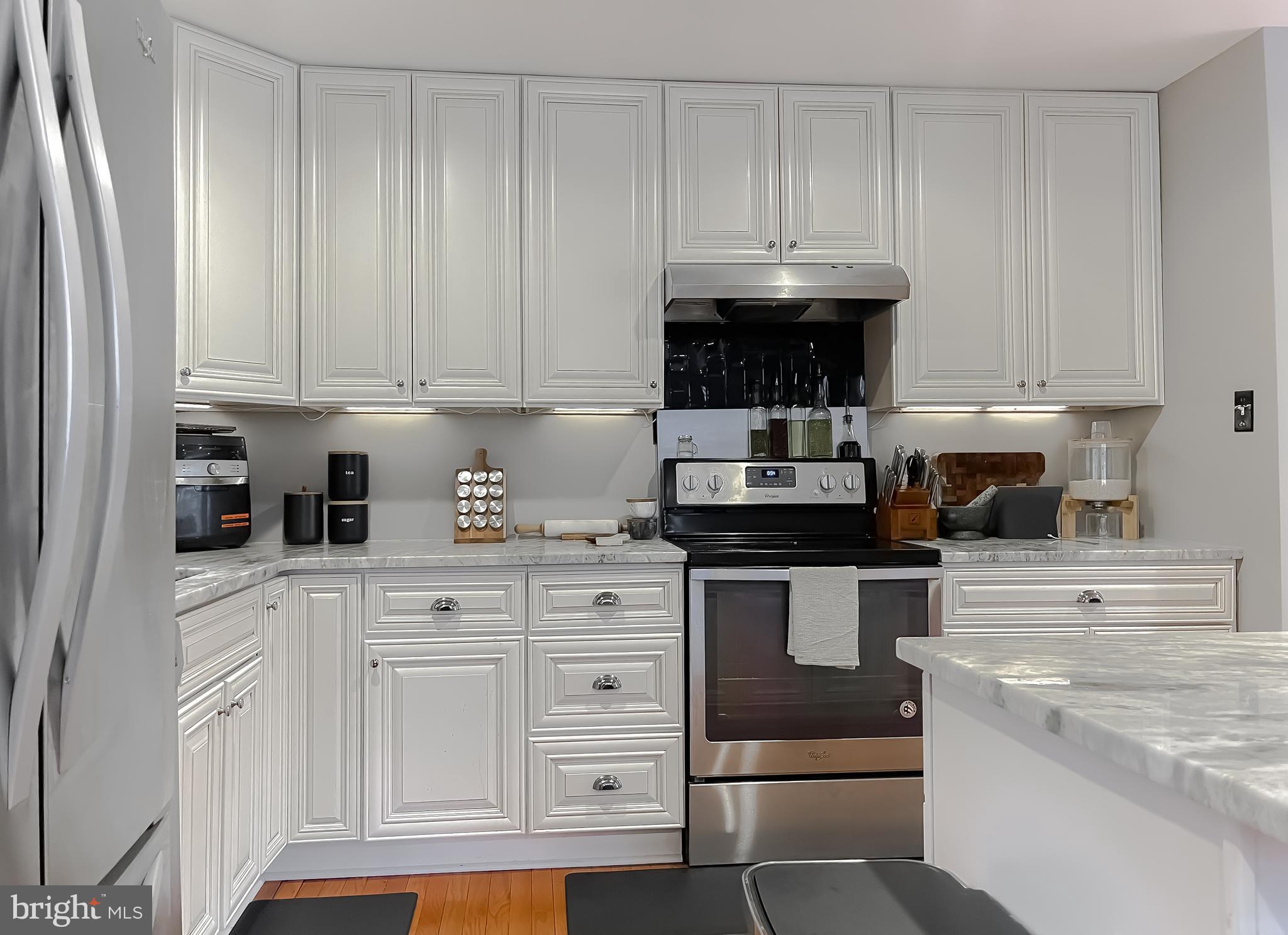 6056 Fir Road St. Leonard, MD 20685 - Photo 12 of 39 a kitchen with stainless steel appliances granite countertop a stove a sink and a white cabinets