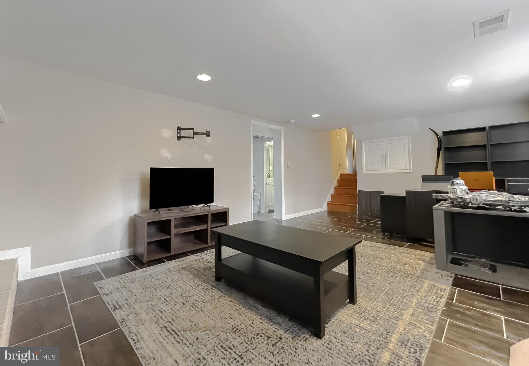 6056 Fir Road St. Leonard, MD 20685 - Photo 31 of 39 a living room with furniture and a flat screen tv