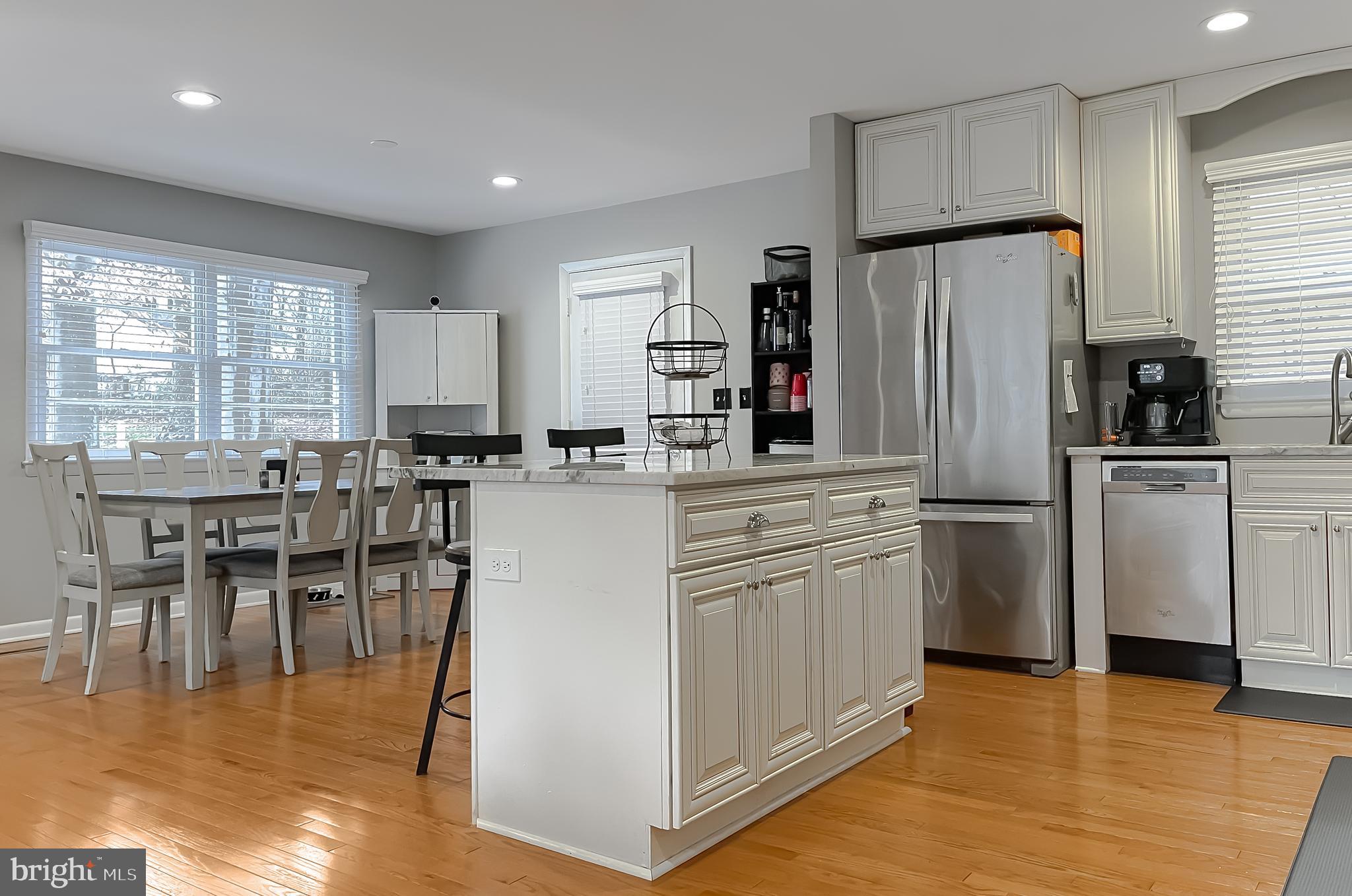 6056 Fir Road St. Leonard, MD 20685 - Photo 6 of 39 a kitchen with stainless steel appliances a refrigerator a stove a sink a dining table and chairs