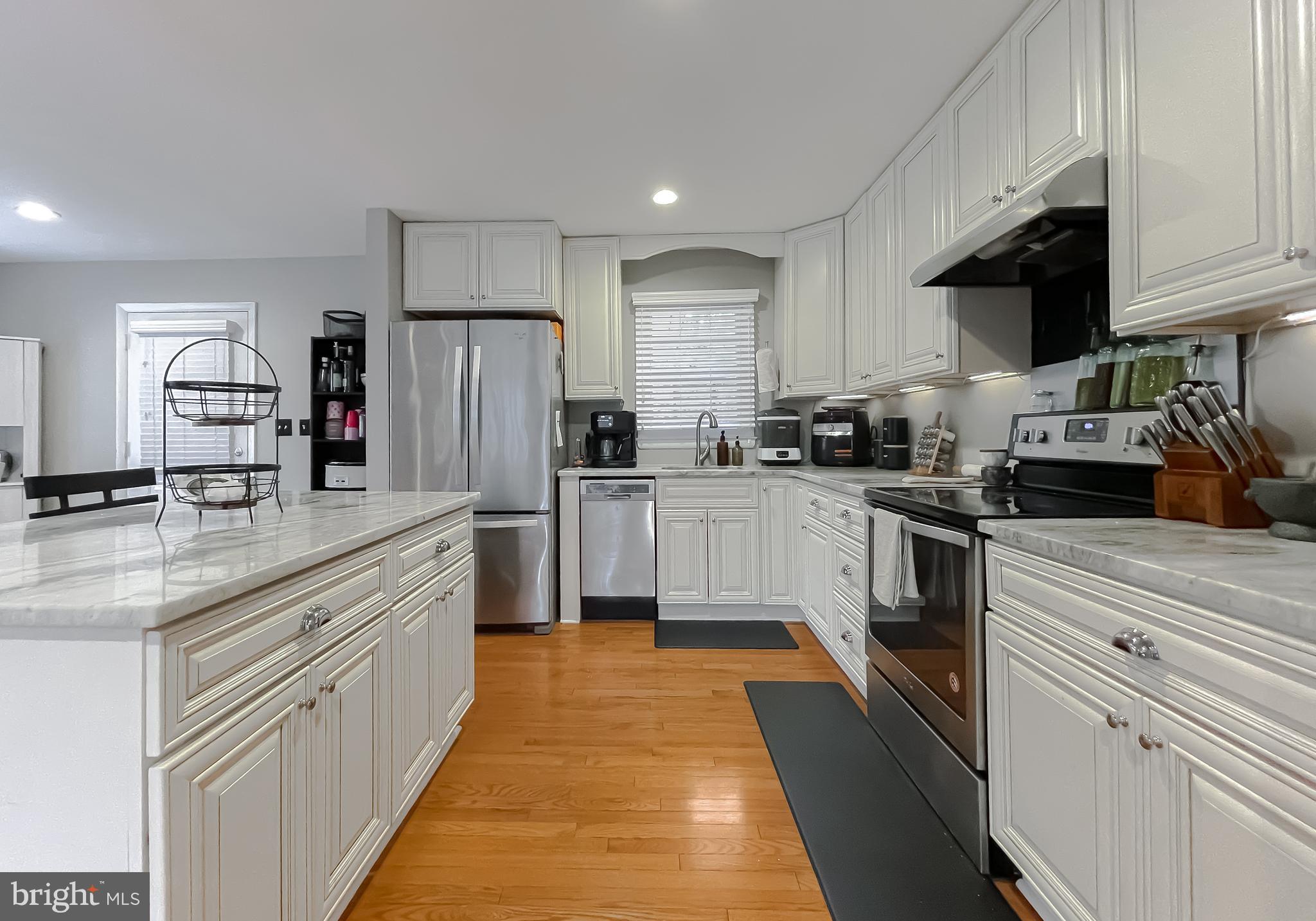 6056 Fir Road St. Leonard, MD 20685 - Photo 8 of 39 a kitchen with granite countertop a sink a counter top space stainless steel appliances and cabinets