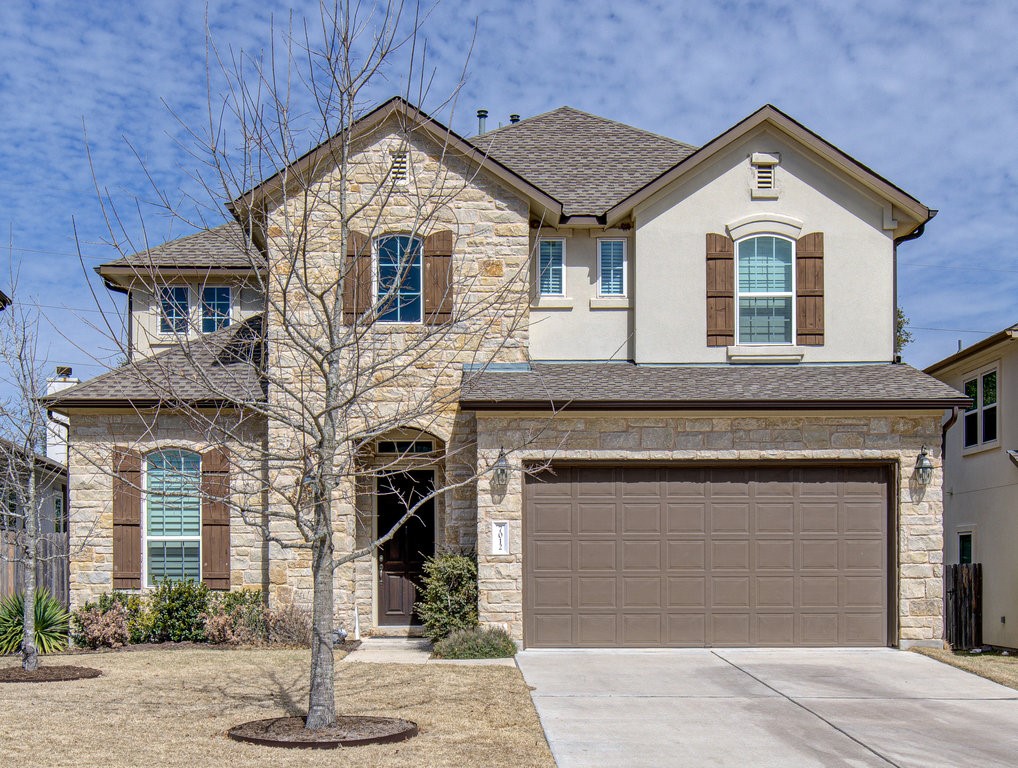 a front view of a house with a yard and garage