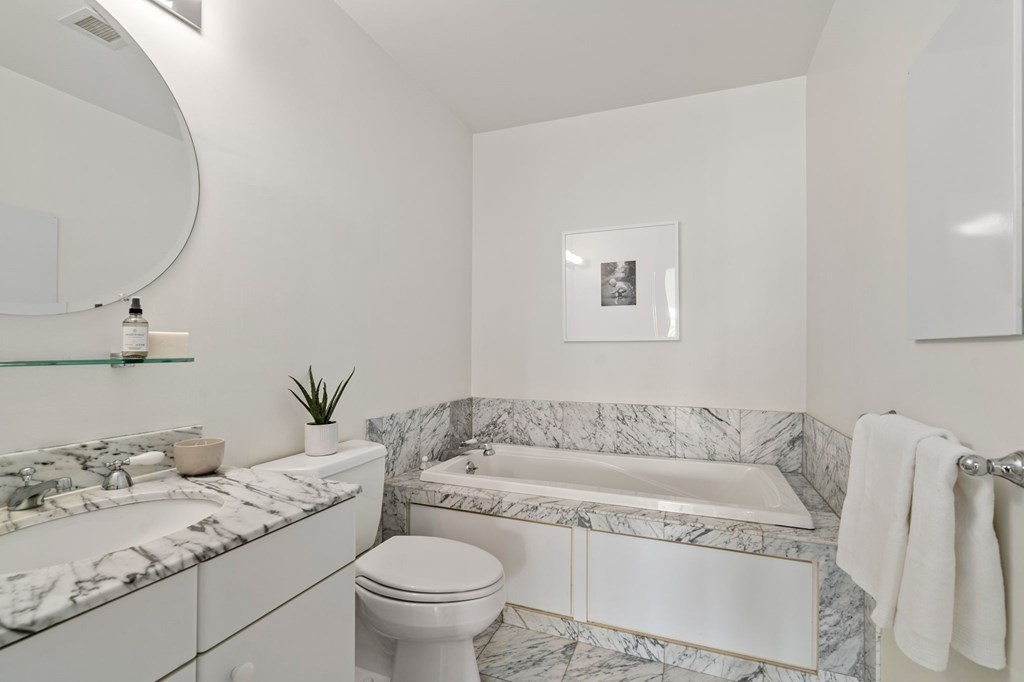 197 8th Street, Unit 330 Boston, MA 02129 - Photo 15 of 39 a spacious bathroom with a granite countertop sink and a mirror
