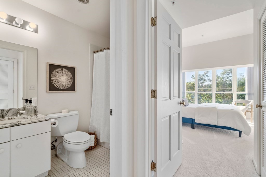197 8th Street, Unit 330 Boston, MA 02129 - Photo 16 of 39 a bathroom with a toilet a sink and a large mirror